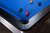 Doc & Holliday Poshy Pool Table | Reverse Rainbow Edition, close-up view of the blue felt surface with billiard balls and corner bumpers.