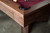Doc & Holliday Arthur Deco Walnut Pool Table, close-up view of the wooden corner with black rubber corner protector and red felt playing surface.