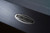 Doc & Holliday TRON Steel Slate Pool Table, close-up of the metallic logo emblem on the table's surface.