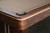 Doc & Holliday Derby Slate Pool Table, made in USA, featuring a close-up of its wooden corner with a black bumper and beige felt playing surface.