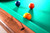 Doc & Holliday Rustic Slate Pool Table, close-up of colorful billiard balls on the green felt surface with wooden frame detail.
