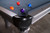 Doc & Holliday Classic Slate Pool Table, gray finish, close-up view showing playing surface with pool balls and corner detail.