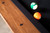 Doc & Holliday Muse Pool Table, close-up of the polished wooden edge and pool balls on the black felt surface