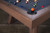 Doc & Holliday George Slate Pool Table, close-up view of the wooden corner and blue felt surface with billiard balls arranged on it.