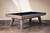 Doc & Holliday George Slate Pool Table by Doc & Holliday with Glazed Pearl finish, featuring a sleek black playing surface and modern wooden legs.