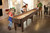 Brunswick Billiards Brunswick Concord Shuffleboard with Split-Playfield, family enjoying game in modern living room.