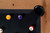 Doc & Holliday Parsons Pool Table in Rustic White Oak, with cue ball and numbered balls on the black felt surface, corner view showing the wood grain and black corner pocket.