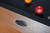 Doc & Holliday Parsons Pool Table in Rustic White Oak, close-up of the wooden frame with brand badge and billiard balls on the playing surface.