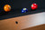Doc & Holliday Parsons Pool Table in Rustic White Oak, close-up of the pool table's edge with billiard balls on the playing surface.