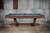 Doc & Holliday Caroline Slate Pool Table, a stylish and durable pool table with a wooden finish and black accents, placed against a rustic metal wall.