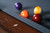 Doc & Holliday Caroline Slate Pool Table, close-up of pool balls on the table with felt surface and wooden edge.