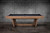 Doc & Holliday Kaci Slate Pool Table in Grey Walnut, modern pool table with sleek wooden frame and black felt surface, against a concrete wall background.