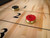Doc & Holliday George Shuffleboard Table, close-up of the shuffleboard playing surface with red and black pucks on it.