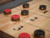 Doc & Holliday George Shuffleboard Table, gray walnut shuffleboard court with red and black pucks lined up on the smooth wooden surface.