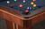 Doc & Holliday Preakness Slate Pool Table in Walnut & Maple, close-up of the corner with colorful billiard balls on the dark felt surface and polished wood finish.