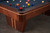 Doc & Holliday Preakness Slate Pool Table in Walnut & Maple, showing the detailed corner of the billiards table with a dark slate playing surface and colorful billiard balls.