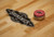 Brunswick Billiards Brunswick Botanic Shuffleboard Table, rustic dark brown and charcoal color with a shuffle puck on the wooden surface.
