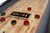 Doc & Holliday George Pool Table & Shuffleboard Combo in Gray Walnut, game surface with shuffleboard pucks and game branding.