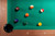 Doc & Holliday Paula Parsons Pool Table in Gray Walnut, view of billiard balls on green felt surface and corner pocket.