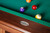 Doc & Holliday Muse Slate Pool Table, close-up view showing the green felt surface and wooden frame with a brand logo sticker.