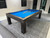 American Heritage Billiards Alta Pool Table in Marble Grey, featuring a modern design with a blue felt surface and wooden finish, set in a contemporary room.