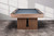 American Heritage Billiards Vancouver Slate Pool Table in Honey Ash with a wooden frame and green felt playing surface.
