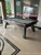 Plank & Hide Co Lennox Steel Slate Pool Table by Plank & Hide, modern steel frame pool table with sleek design indoors near glass windows with reflection of trees outside.