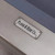 Plank & Hide Co Lexa Steel Slate Pool Table, close-up of the metal brand plate on the pool table with gun metal finish and part of the blue felt surface.