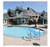 First Team Inc First Team HYDROCHAMP Adjustable Pool Side Basketball Hoop, installed beside a swimming pool at a luxurious house.