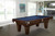 Brunswick Billiards Brunswick Allenton Slate Pool Table in Espresso, in a stylish living room with large windows and modern decor.