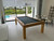 Brunswick Billiards Brunswick Hickory 8' Slate Pool Table - Natural Hickory Finish, indoor game room with large sliding glass doors to backyard, modern chairs, and scenery outside.
