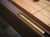 Angled close-up of the recessed scoring system on the Doc & Holliday Paula Parsons Shuffleboard Table, featuring sleek brass scoring tiles set into Antique Coffee alder wood.