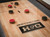 Overhead image of Doc & Holliday Paula Parsons Shuffleboard Table showing maple butcher block playfield with 1-2-3 scoring zones and red and black shuffleboard pucks.