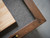 Doc & Holliday Paula Parsons Shuffleboard Table in Antique Coffee, close-up of the corner showing the wood finish and textured playing surface.