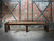 Doc & Holliday Paula Parsons Shuffleboard Table in Antique Coffee, modern wooden shuffleboard table against an exposed brick wall.