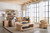 Hooker Furniture Retreat Rectangle Cocktail Table in a modern living room with beige sofa, armchair, and large windows with white curtains, styled with decorative accessories.