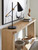 Hooker Furniture Retreat Console Table, modern light wood finish console table with a lower shelf displaying books and decorative objects.