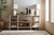 Hooker Furniture Vineyard Row Console, a rustic wooden console table with a natural finish displaying decorative pottery, books, and sculptures in a stylish living room.