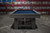 Doc & Holliday Hank Slate Pool Table – Marble Grey Finish, front view of a stylish pool table with marble grey finish and blue felt surface in an industrial setting.