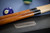 Plank & Hide Co Beaumont Slate Pool Table by Plank & Hide – Black Ash, close-up of pool cues and a blue billiard ball on a black pool table.