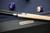 Plank & Hide Co Isaac Slate Pool Table in Black Ash, with pool cues and billiard balls on the table.