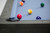 Beaumont slate pool table in Marble Grey with Championship Academy Blue felt, shown in a top-down corner detail highlighting the black leather pocket and clean rail lines.
