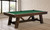 C.L. Bailey Tunbridge Pool Table in Weathered Brown, inside a modern room with large windows and wooden flooring.