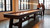C.L. Bailey Tunbridge Shuffleboard in Weathered Brown, large wooden shuffleboard table in an industrial style room with two people playing and enjoying the game.