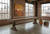 C.L. Bailey Viking Shuffleboard in Antique Oak, a wooden shuffleboard table with rustic finish, situated in a modern industrial-style room with brick walls and large windows.