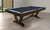 C.L. Bailey Skylar Pool Table in Warm Chestnut, a stylish billiards table with a dark wood finish, in a modern indoor setting.