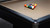 C.L. Bailey Addison Slate Pool Table in Black, with a set of billiard balls arranged on its beige felt surface.