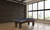 C.L. Bailey Adrian Slate Pool Table, a classic wooden pool table in a spacious room with large windows and city view.