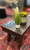 C.L. Bailey Tunbridge Pool Table & Shuffleboard in Weathered Brown, with a wooden tabletop, a potted plant, and a wire basket filled with yellow and green balls on a red patterned carpet.