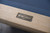 Doc & Holliday Kaci Slate Pool Table in Natural Ash, close-up of the metal branding plate on the wooden frame.